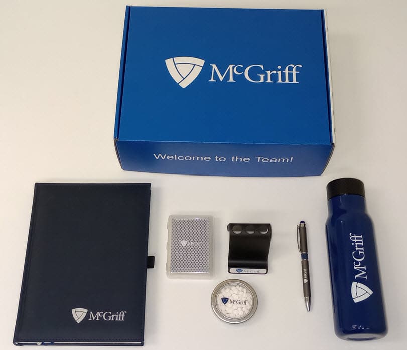 McGriff Insurance new hire custom blue welcome box with contents curated by Concepts & Associates - journal, mints, pen, bottle, etc.